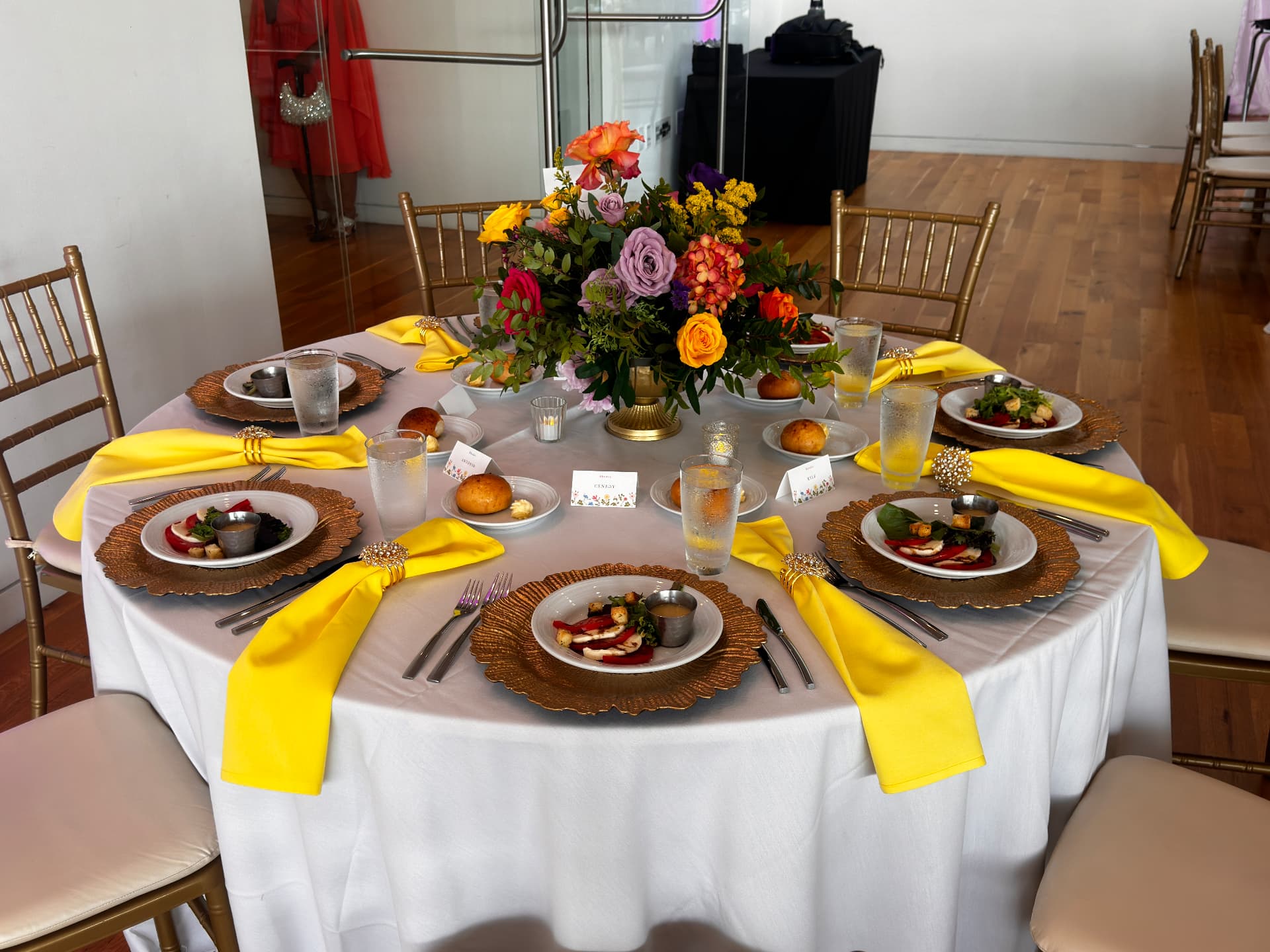 Gold chargers, bright napkins and crystal rings at a placed setting — Weddings by Good Time Mascots in Columbus, Ohio