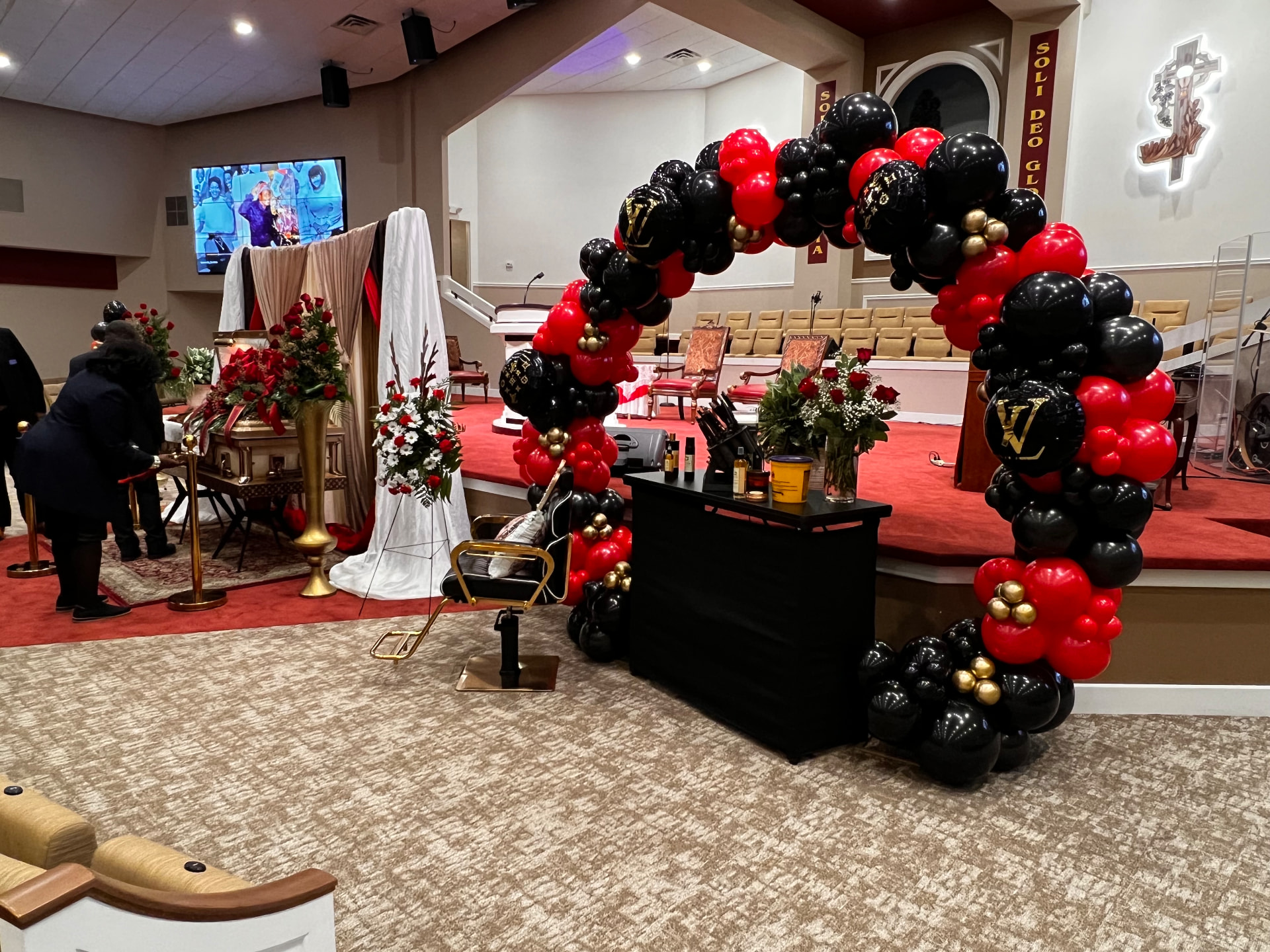 Sanctuary celebration of life with draping, florals and a red-and-black balloon arch — Celebration of Life & Memorials by Good Time Mascots in Columbus, Ohio