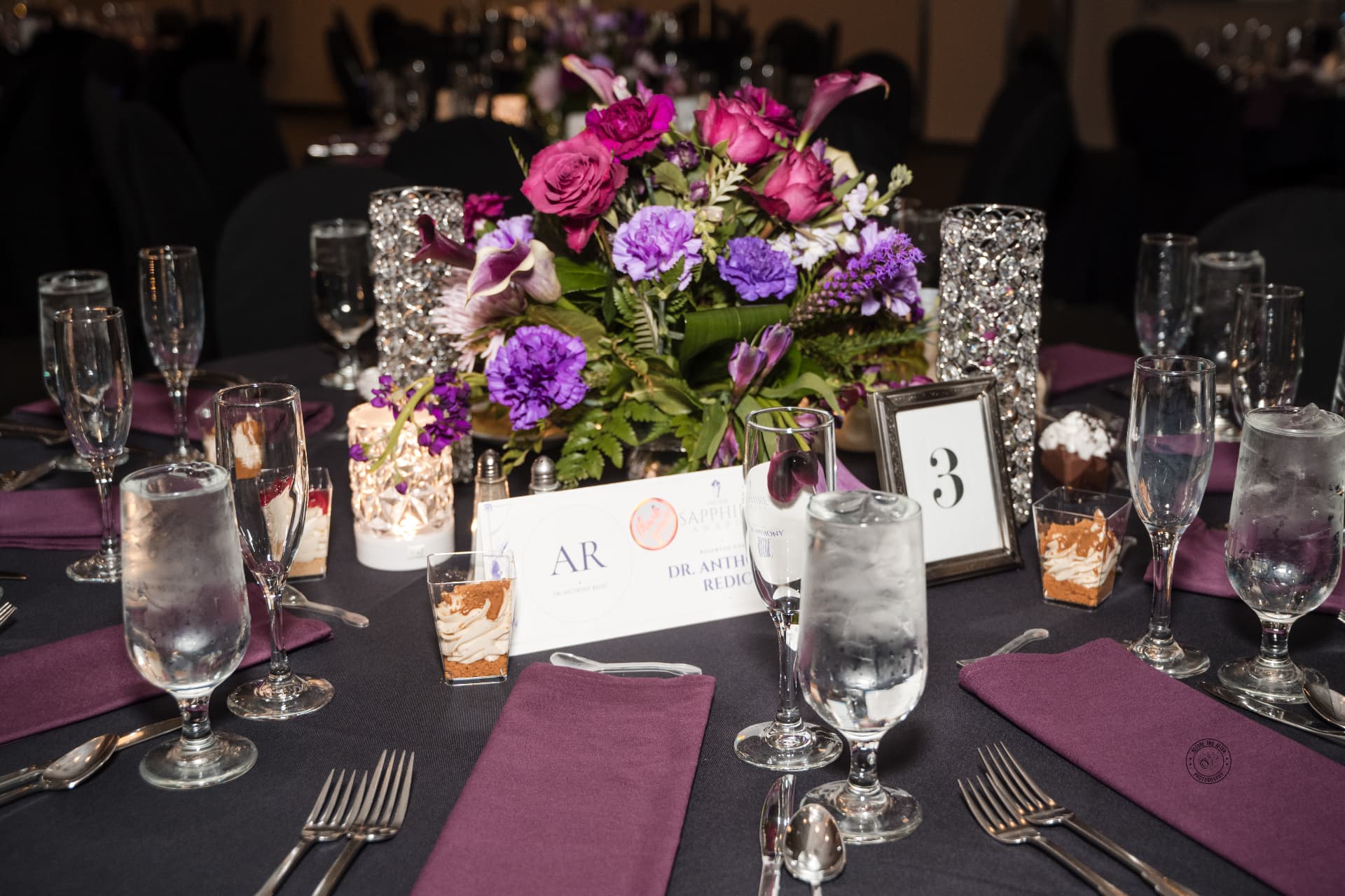 Guest table with jewel-toned centerpiece & plum napkins — Corporate & Brand Experiences by Good Time Mascots in Columbus, Ohio