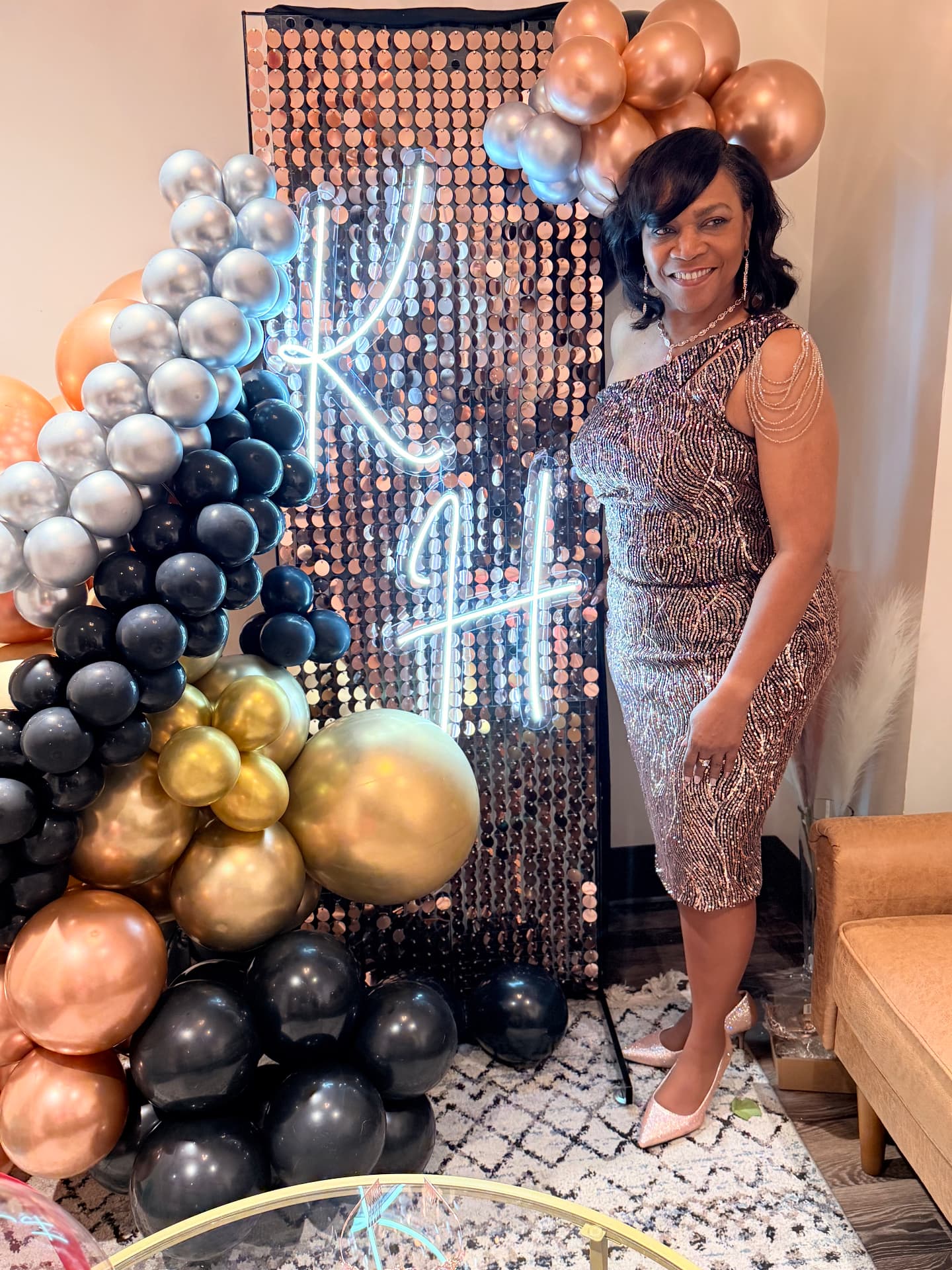 Rose gold shimmer wall with a neon monogram and organic garland — Balloon Décor by Good Time Mascots in Columbus, Ohio